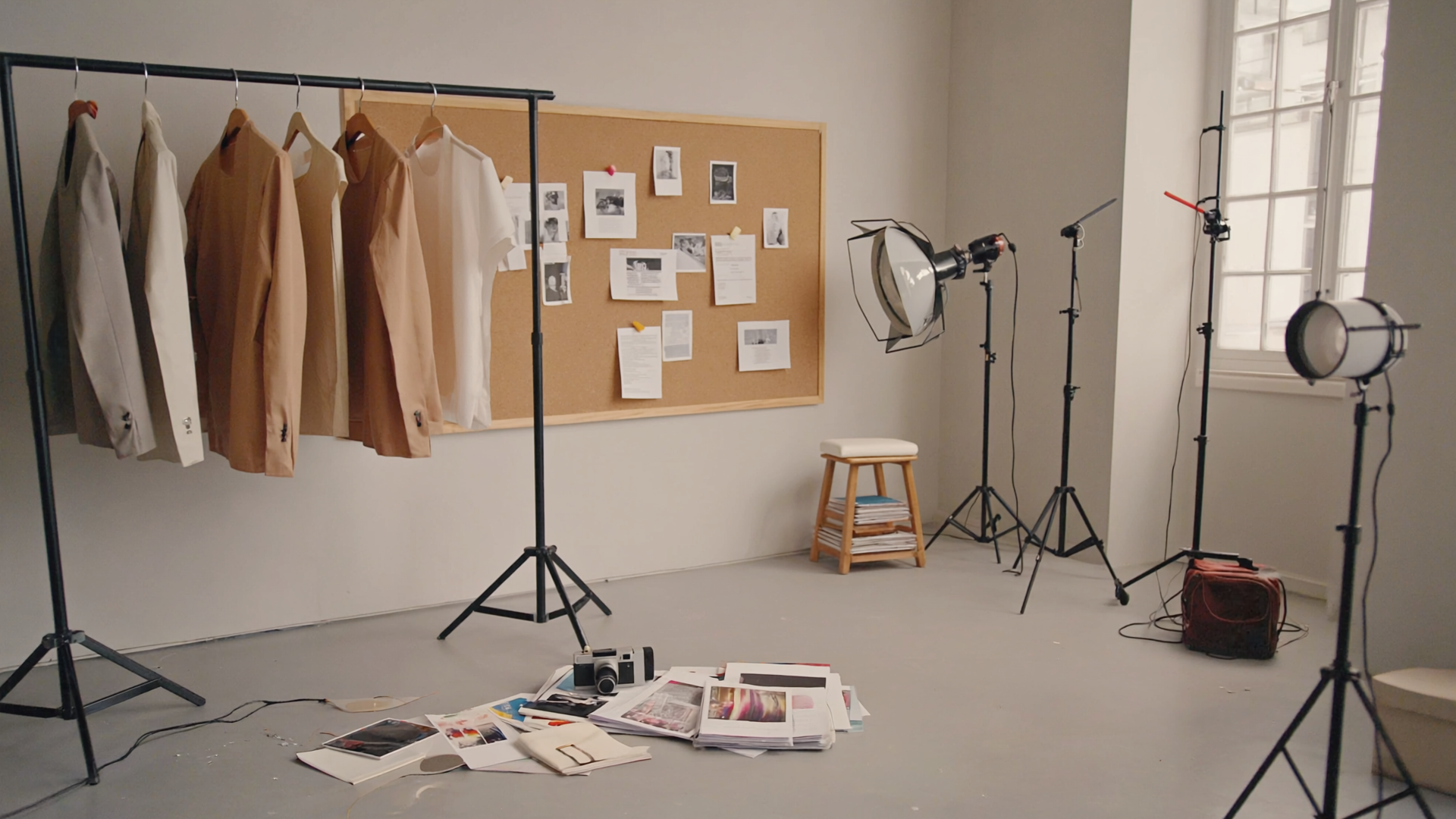 Leeres Mode-Studio: Kleiderstange mit Garment Bags, Kontaktabzüge, professionelles Licht.